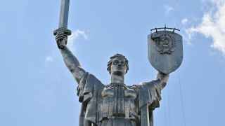 Рабочие меняют герб СССР на герб Украины на щите монумента «Родина-мать» в Киеве