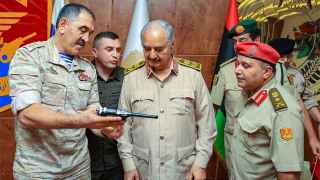 Замминистра обороны России Юнус-Бек Евкуров преподносит пистолет в подарок ливийскому военачальнику Халифе Хафтару во время визита в Бенгази